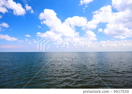 Cloudy blue sky above a surface of the sea Cloudy blue sky above a surface of the sea 9917830