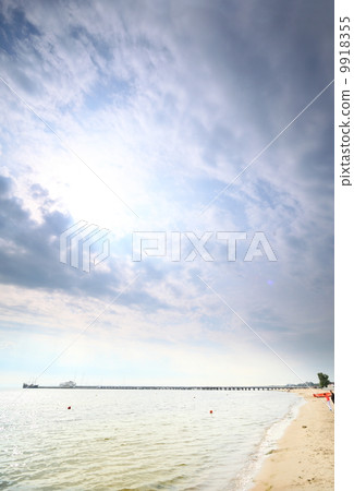 Cloudy blue sky above a surface of the sea Cloudy blue sky above a surface of the sea 9918355
