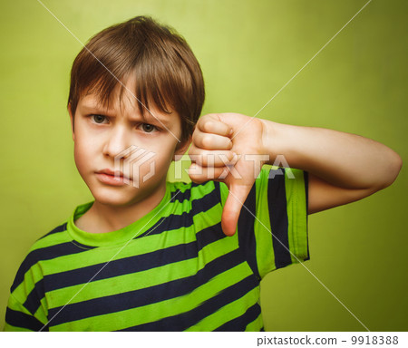 baby boy teenager showing thumbs down on the big green backgroun 9918388
