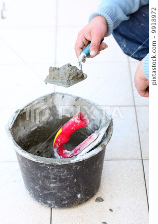 Construction worker is tiling at home Construction worker is tiling at home 9918972