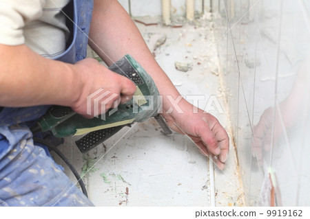 manual worker disassembling old floor tiles 9919162