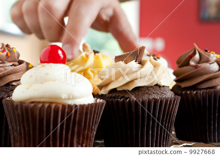 Hand Grabbing a Gourmet Cupcake 9927668