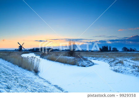 windmill by frozen river at sunrise, Groningen windmill by frozen river at sunrise, Groningen 9929358