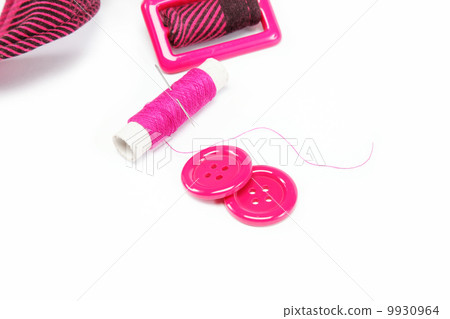 Reel of thread with a needle, buttons and a belt on a white back Reel of thread with a needle, buttons and a belt on a white back 9930964