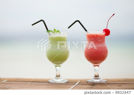 Two fresh fruit juices on a tropical beach 9932847