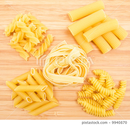 Different kinds of italian pasta on the wooden background 9940870