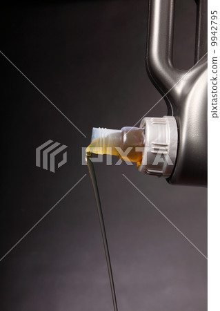 Can with car engine oil pouring black background 9942795