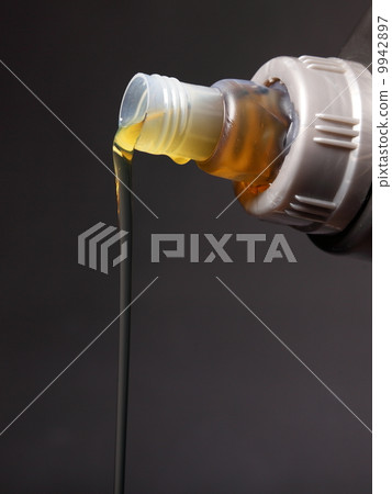 Can with car engine oil pouring black background Can with car engine oil pouring black background 9942897