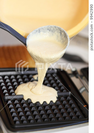 Waffle iron preparing waffles in kitchen 9942990