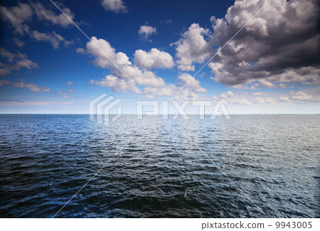 Cloudy blue sky above a surface of the sea Cloudy blue sky above a surface of the sea 9943005