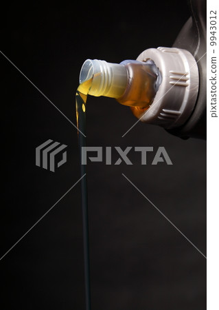 Can with car engine oil pouring black background Can with car engine oil pouring black background 9943012