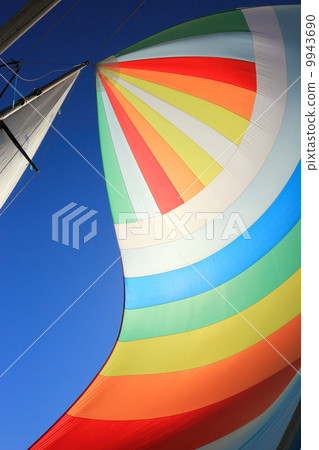 The wind has filled colorful spinnaker sail 9943690