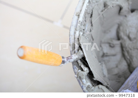 Dirty trowel and bucket on building site. Renovation at home Dirty trowel and bucket on building site. Renovation at home 9947318
