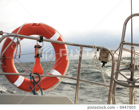 red lifebuoy on sail and stormy sky sea red lifebuoy on sail and stormy sky sea 9947805