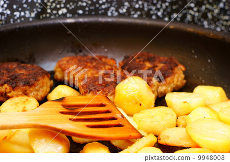 Seasoned potato slices in skillet pan in kitchen 9948008
