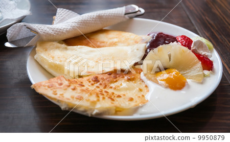Pancakes on white plate and dark background with cream, strawber 9950879