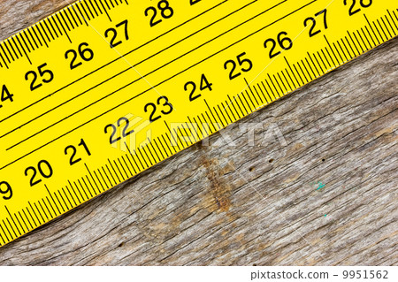 Yellow ruler on a wooden background Yellow ruler on a wooden background 9951562