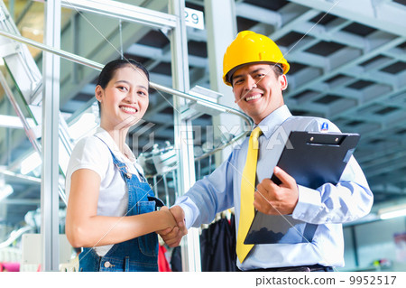 Asian foreman in textile factory giving training 9952517
