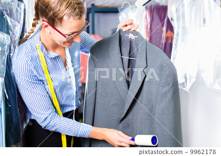Cleaner in laundry shop checking clean clothes Cleaner in laundry shop checking clean clothes 9962178