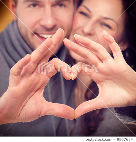 Valentine Couple Making Shape of Heart by their Hands 9967654