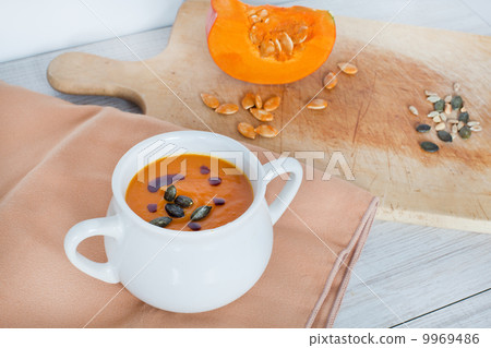 Pumpkin vegetable cream soup in white bowl with piece pumpkin Pumpkin vegetable cream soup in white bowl with piece pumpkin 9969486