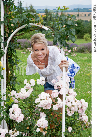 Beautiful blonde woman posing with a blooming rose Beautiful blonde woman posing with a blooming rose 9970982