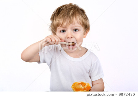 Little boy with eating cheesecake muffin. 9972450