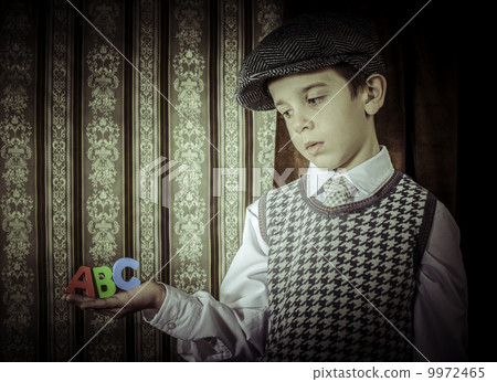 Child in vintage clothes hold letters a b c 9972465