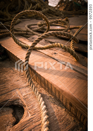 Coarse coconut rope at wooden fishing boat deck 9972893