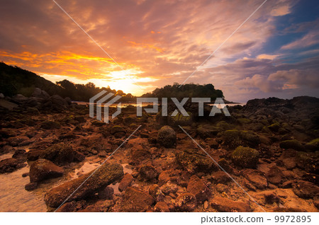 Sunset at tropical beach with rocks and stones 9972895