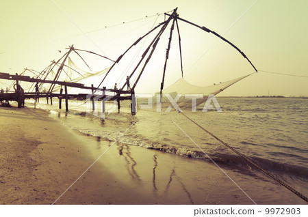 Sunset at tropical beach with chinese fishing nets. India Sunset at tropical beach with chinese fishing nets. India 9972903