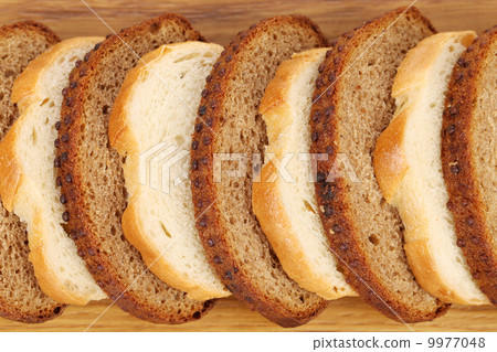 Sliced white and brown loaf of bread. Sliced white and brown loaf of bread. 9977048