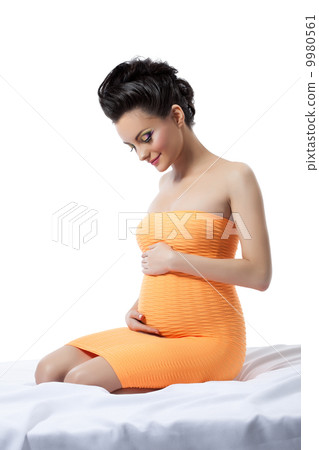 Elegant pregnant woman posing in studio 9980561