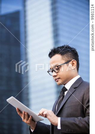 Young male malay executive using a tablet Young male malay executive using a tablet 9981114