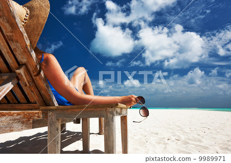Woman at beach holding sunglasses Woman at beach holding sunglasses 9989971