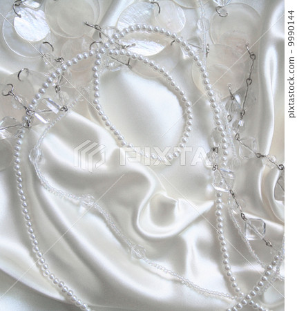 White pearls and nacreous beeds on white silk as wedding backgro White pearls and nacreous beeds on white silk as wedding backgro 9990144