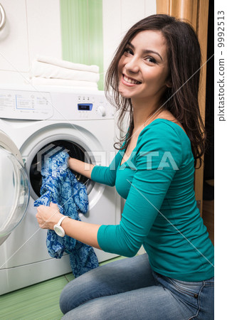 Putting a cloth into washing machine 9992513