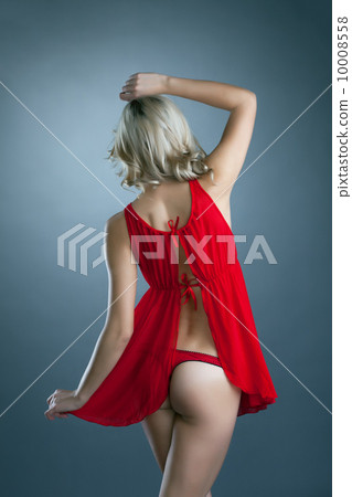 Rear view of slim blonde posing in erotic negligee 10008558
