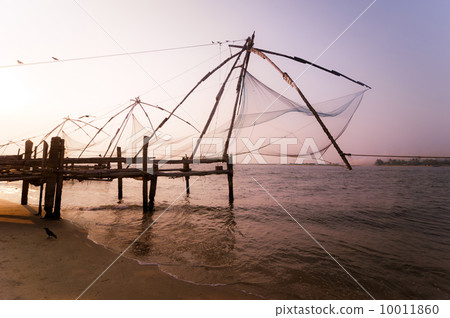 Sunset at tropical beach with chinese fishing nets Sunset at tropical beach with chinese fishing nets 10011860