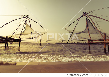 Sunset at tropical beach with chinese fishing nets Sunset at tropical beach with chinese fishing nets 10011862