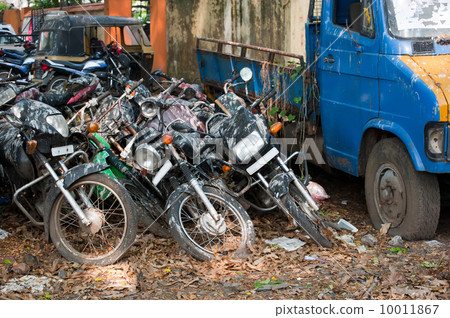 Old broken motorbikes and car in junkyard. India 10011867