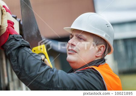 Carpenter with saw near root at outdoor 10021895