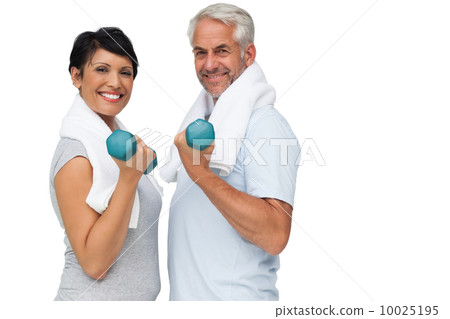 Fit mature couple exercising with dumbbells Fit mature couple exercising with dumbbells 10025195