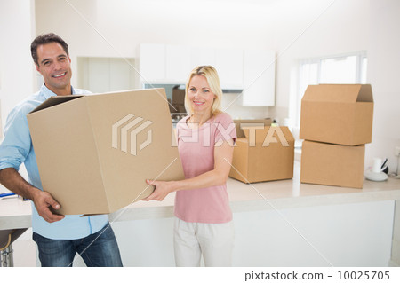 Smiling couple moving together in a new house Smiling couple moving together in a new house 10025705