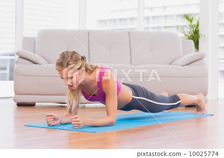 Fit blonde in plank position on exercise mat Fit blonde in plank position on exercise mat 10025774