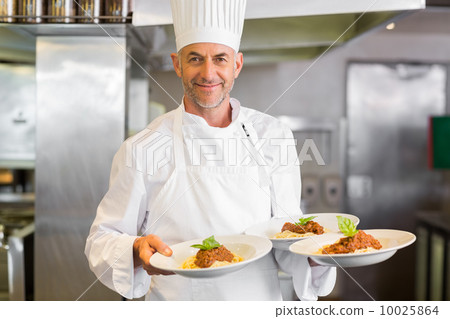 Confident male chef with cooked food in kitchen Confident male chef with cooked food in kitchen 10025864