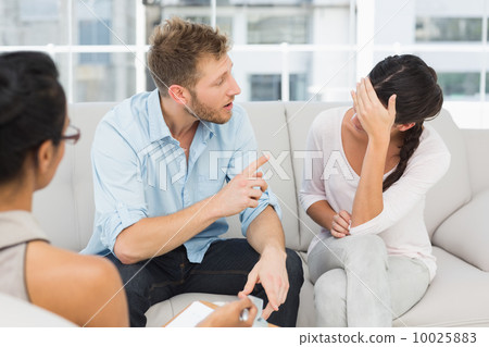 Unhappy couple fighting at therapy session 10025883