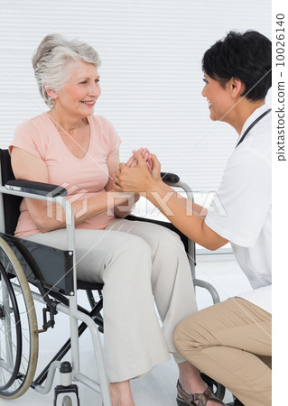 Doctor talking to a senior patient in wheelchair Doctor talking to a senior patient in wheelchair 10026140