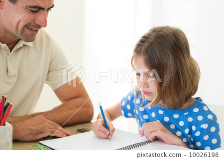 Father looking at daughter coloring 10026198