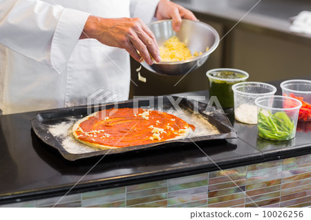 Mid section of a chef garnishing food in kitchen Mid section of a chef garnishing food in kitchen 10026256